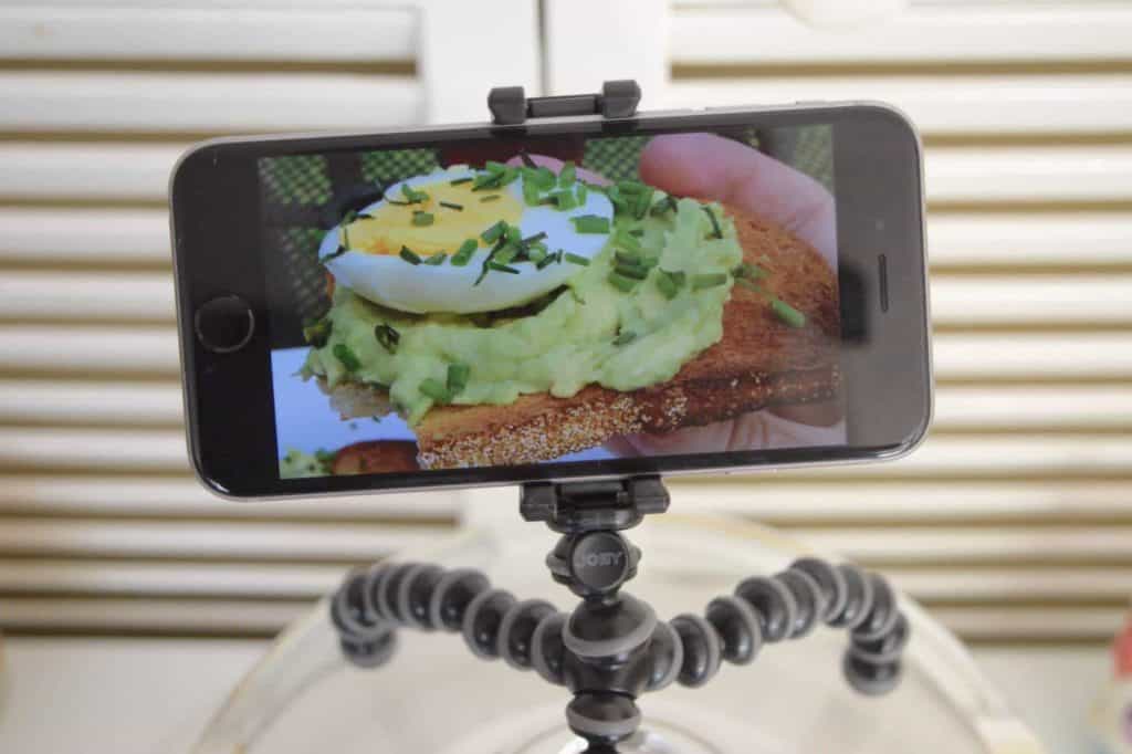 Phone on a GorillaPod tripod featuring a picture of avocado and egg toast 